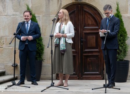 fotografia. art piknik w willi decjusza. konsul węgier Tibor Gerencsér przemawia u stóp schodów przed willą, obok dyrektorka instytutu kultury willa decjusza dominika kasprowicz.